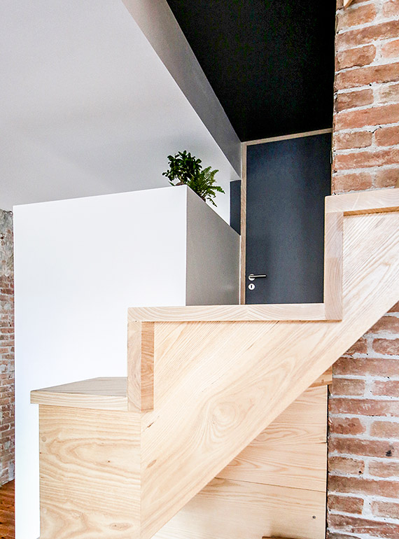 escalier en bois et mur en briques